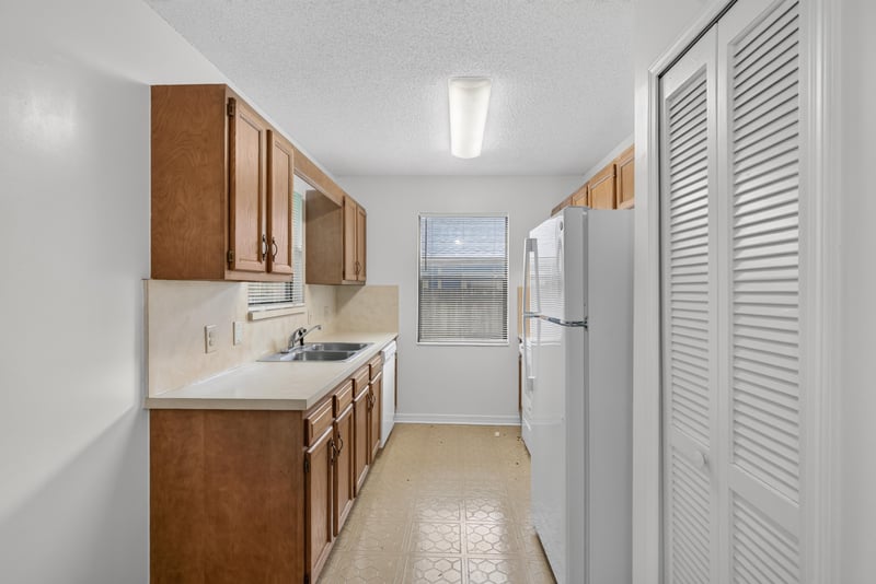 Galley kitchen with pass-through and refrigerator at 1445 Classic Oak Rd W, Jacksonville, FL