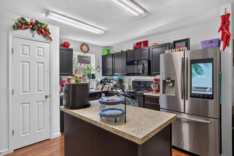 Kitchen with dark cabinets and stainless refrigerator at 518 Matecumbe Ct, Macclenny, FL