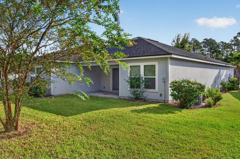 Backyard with tree and open grass at 95221 Siena Ct, Fernandina Beach, FL 32034