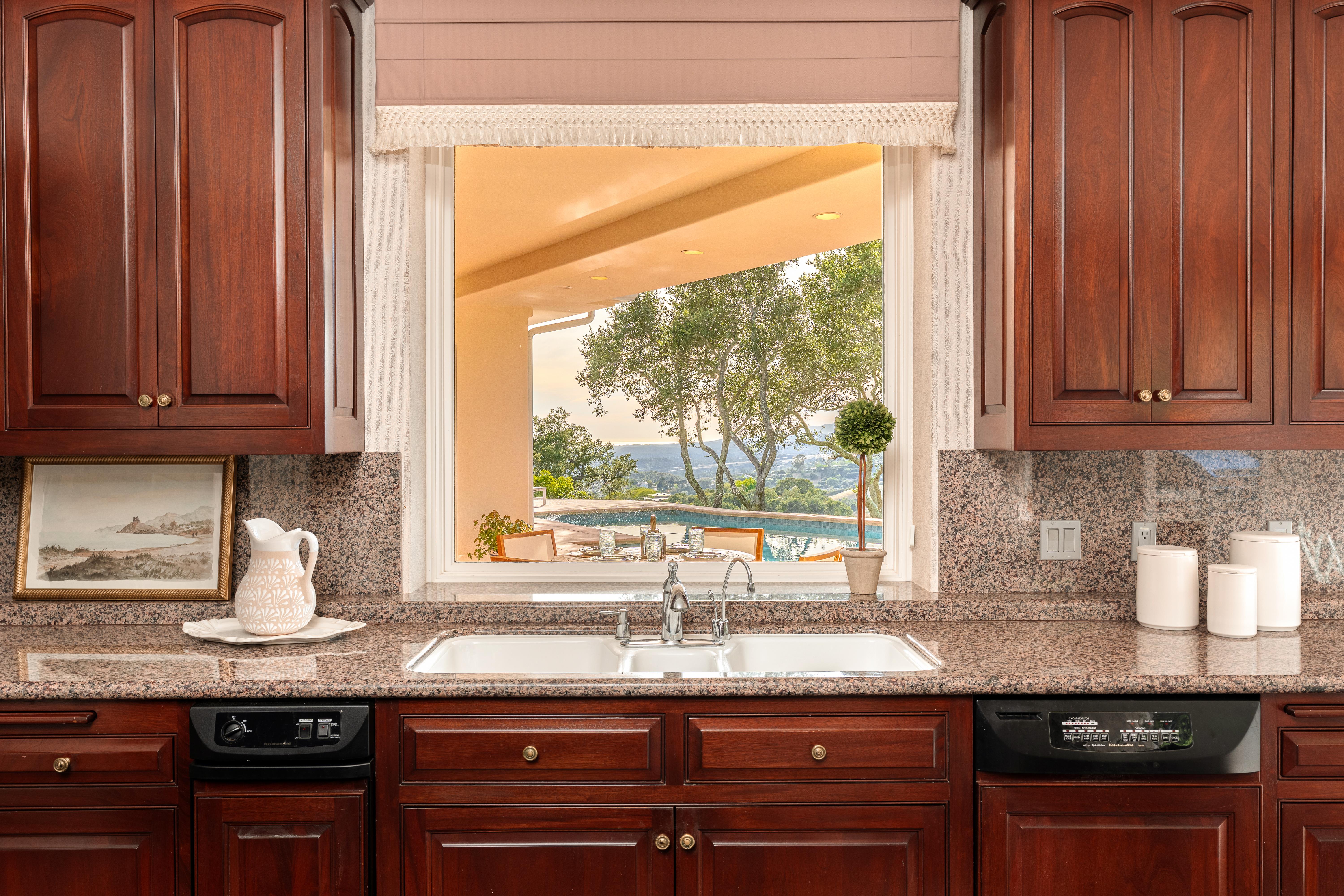 Aerial drone photography of hilltop estate at 450 El Cielito Rd, Santa Barbara — real estate drone photography revealing roofline, mature landscaping, and sweeping Pacific Ocean and Channel Islands panorama above the American Riviera. Our team captured still photography, aerial drone photography, twilight photography, a Matterport virtual tour, a 2D floor plan, and a custom property website from afternoon through twilight.