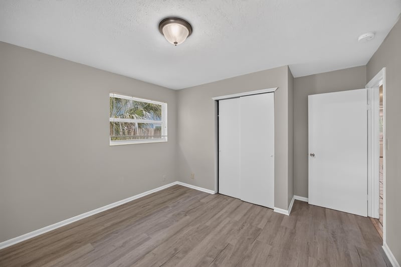 Bedroom with wood-look flooring and closet doors at 5527 Beney Rd, Jacksonville, FL 32207