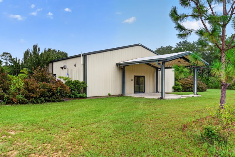 Front exterior view of the metal building from across the lawn at 1038 County Rd 315, Melrose