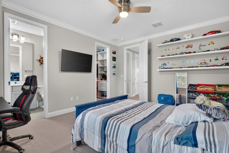 Bedroom with TV and built-in shelving at 22 Azura Point