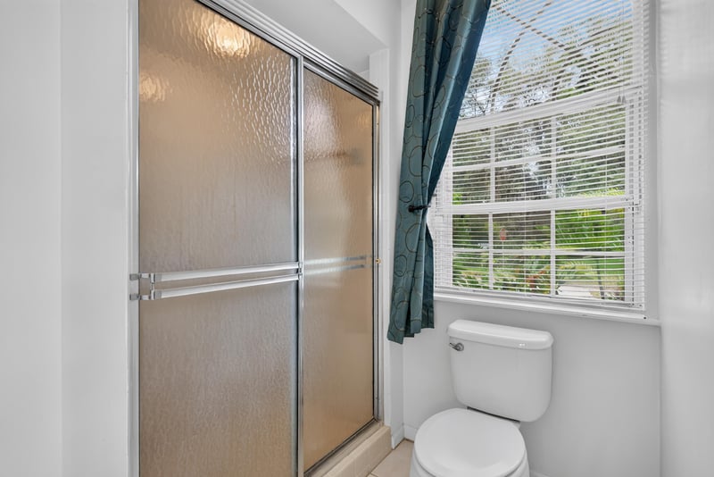 Primary bathroom glass shower and soaking tub at 12810 Swamp Owl Ln