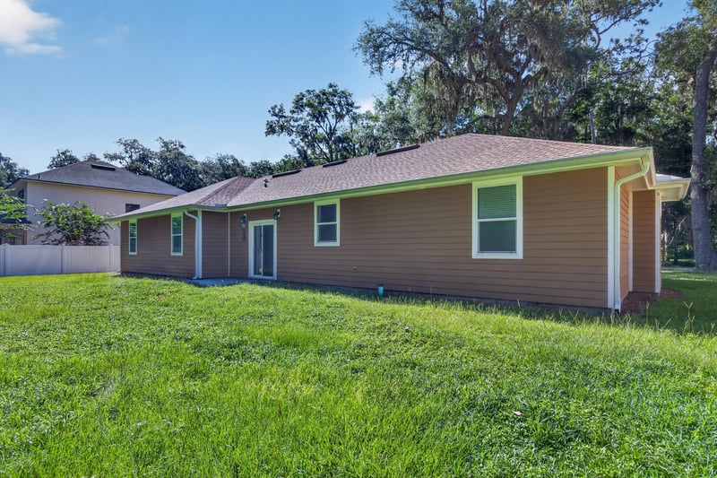 Side exterior view with grass yard at 1012 Fruit Cove Rd, Jacksonville, FL 32259