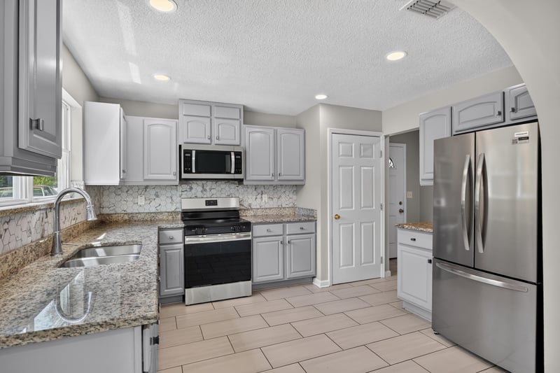 Kitchen with stove and granite counters at 7015 Miss Muffet Ln N, Jacksonville, FL 32210