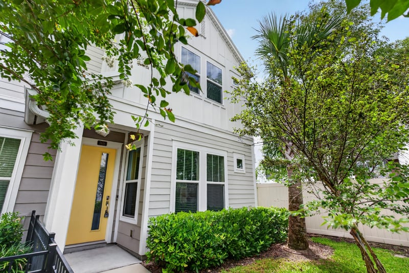 Front entry with yellow door and palm tree at 7446 Loggerhead Ct, Jacksonville, FL 32256