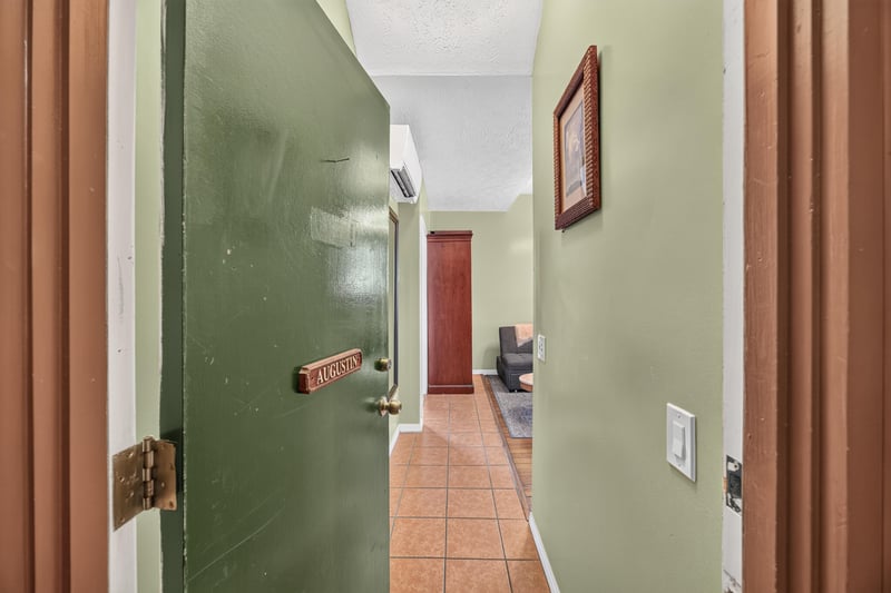 Interior hallway with a green door and tile floor at 115 Cordova St, St. Augustine, FL