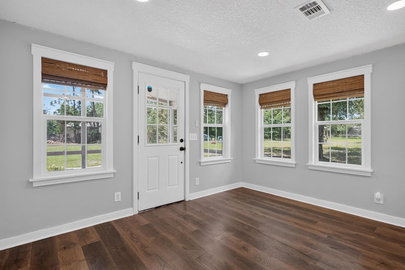Living room with wood floors and large windows at 4890 McAllister Rd, Middleburg, FL 32068