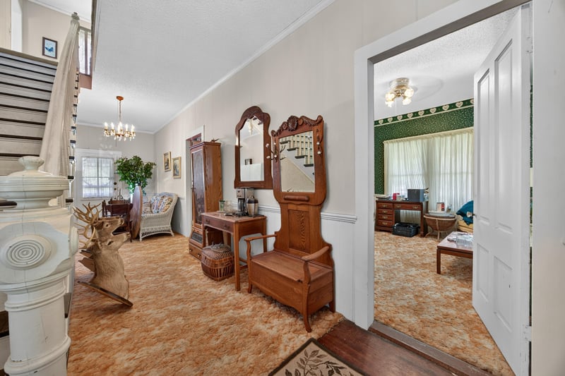 Staircase with wood banister and vintage dresser at 1173 US-17, Satsuma, FL 32189