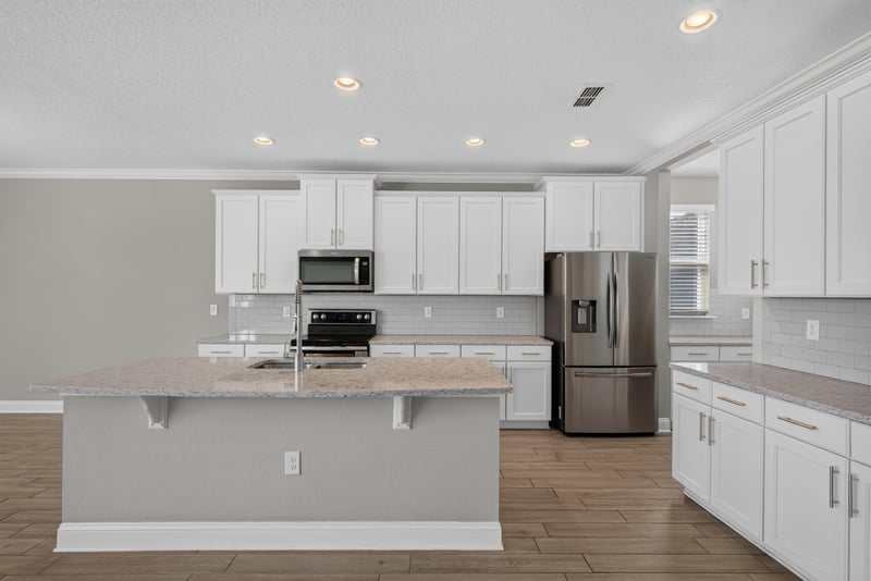 Kitchen island with granite counter and stainless appliances at 2580 Cold Stream Ln, Green Cove Springs, FL 32043