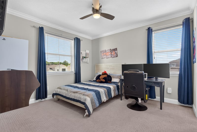 Bedroom with desk and blue curtains at 22 Azura Point