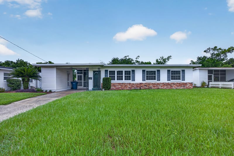 Front exterior with blue door and green lawn at 11462 Elane Dr, Jacksonville, FL