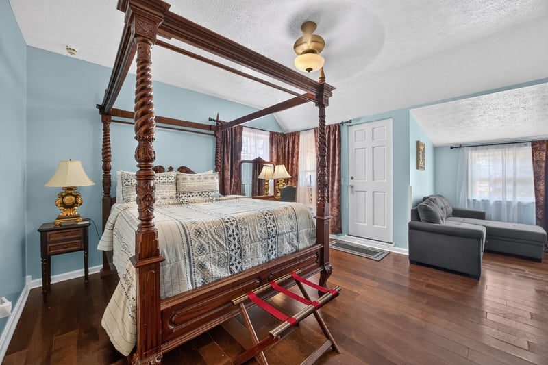 Bedroom with a four-poster bed and wood floors at 115 Cordova St, St. Augustine, FL
