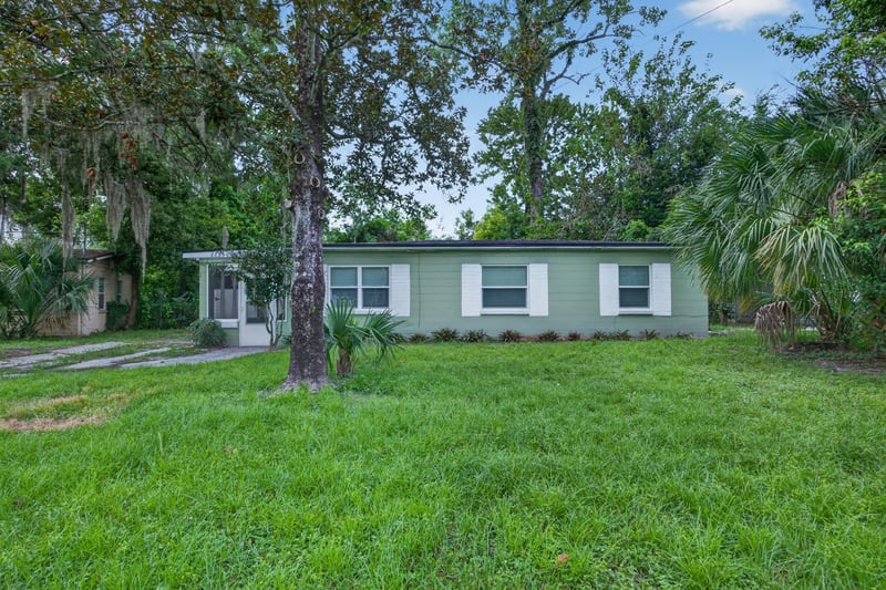 Front exterior, green siding and shade trees at 2256 Inwood Cir S, Jacksonville, FL