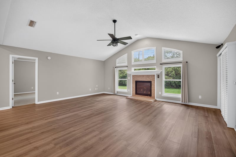 Empty living room with fireplace and natural light at 1955 GUARDED Way, Fleming Island, FL 32003