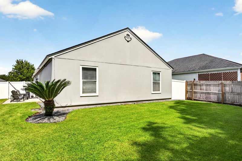 Backyard patio with chairs and fenced lawn at 3067 Wavering Ln, Middleburg, FL 32068