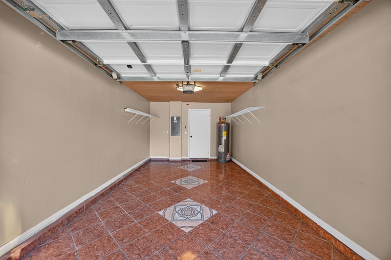 Garage interior with tile flooring and entry door at 7723 Playschool Ln, Jacksonville, FL