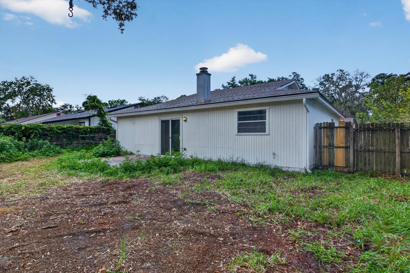 Rear exterior with chimney and side yard at 1040 Willow Cove Ct E, Jacksonville, FL 32233