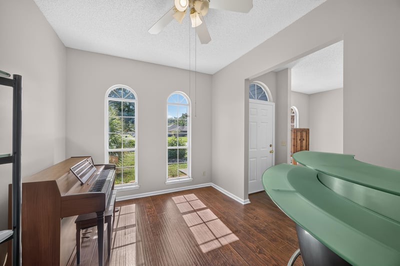 Room with arched windows and upright piano at 11828 Heather Grove Ln, Jacksonville, FL