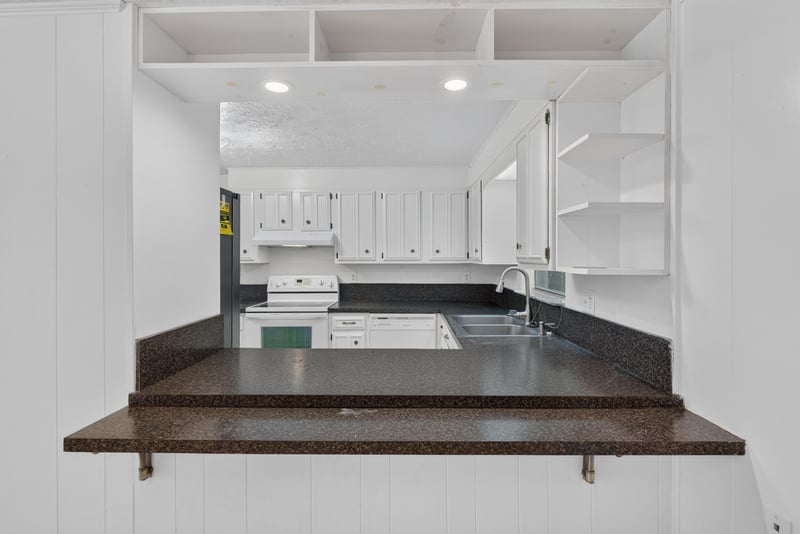Kitchen pass-through counter and white cabinets at 9954 Larkdale Ct, Jacksonville, FL 32257