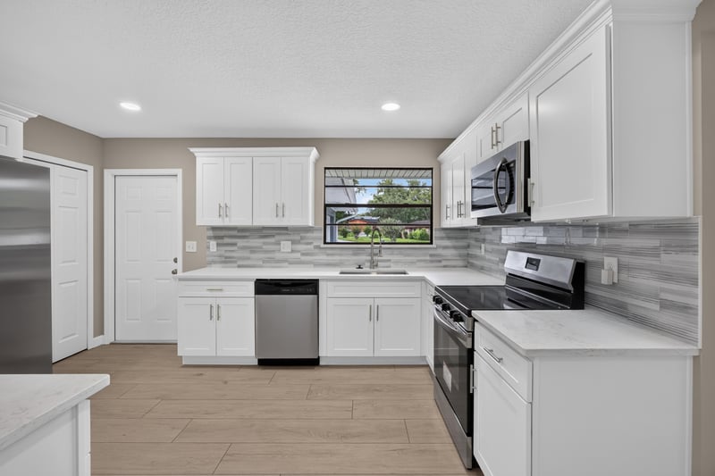 Kitchen with white cabinets and stainless steel appliances at 4117 Wilcrest Ct, Jacksonville, FL 32277