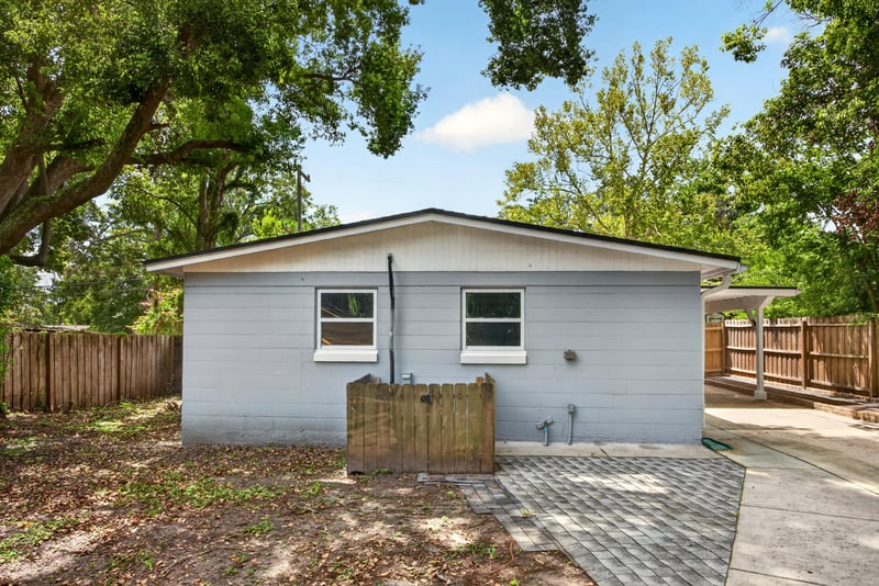 Side exterior view of concrete block home at 7015 Miss Muffet Ln N, Jacksonville, FL 32210