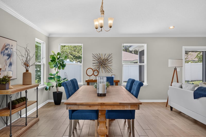 Dining and living area with wood table and blue chairs at 10066 Andean Fox Dr, Jacksonville, FL 32222