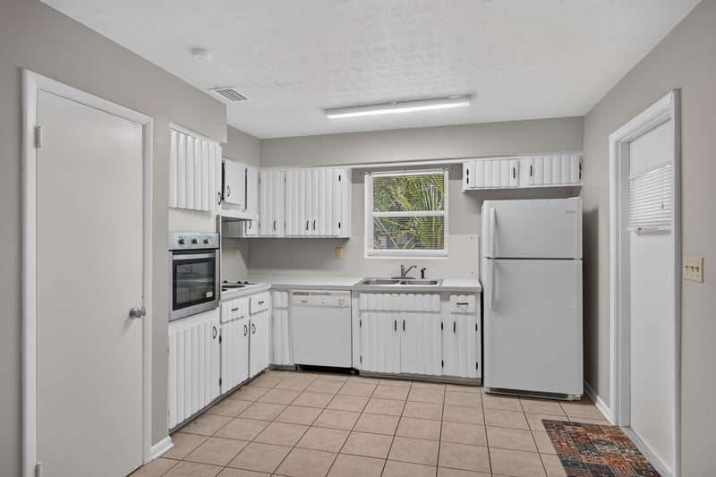 Kitchen view with refrigerator and white cabinetry at 5527 Beney Rd, Jacksonville, FL 32207