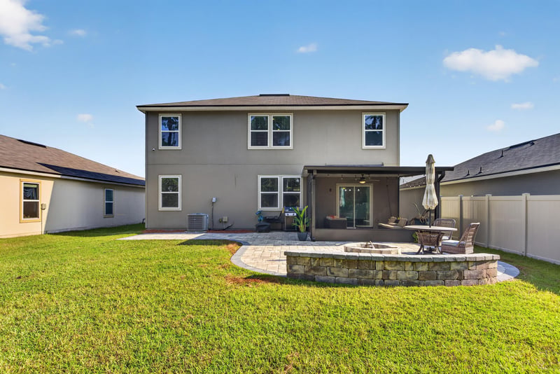 Rear exterior with patio and fire pit at 65255 Frst Glen Ln, Yulee, FL 32097