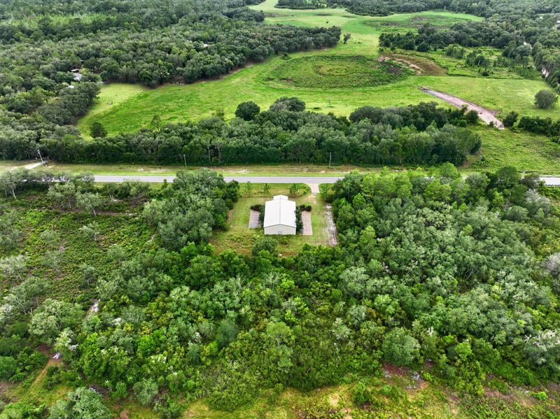 Drone aerial of open field and tree line near the property at 1038 County Rd 315, Melrose