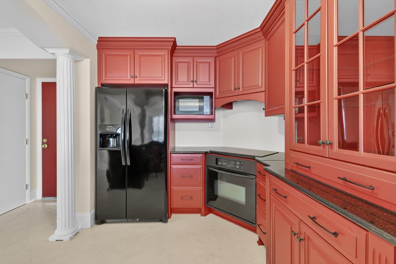 Kitchen with black refrigerator and red cabinets at 1301 1st St S