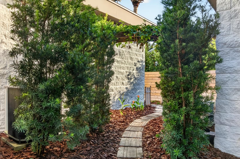 Side yard walkway between stone wall and greenery at 722 3rd Ave N, Jacksonville Beach, FL