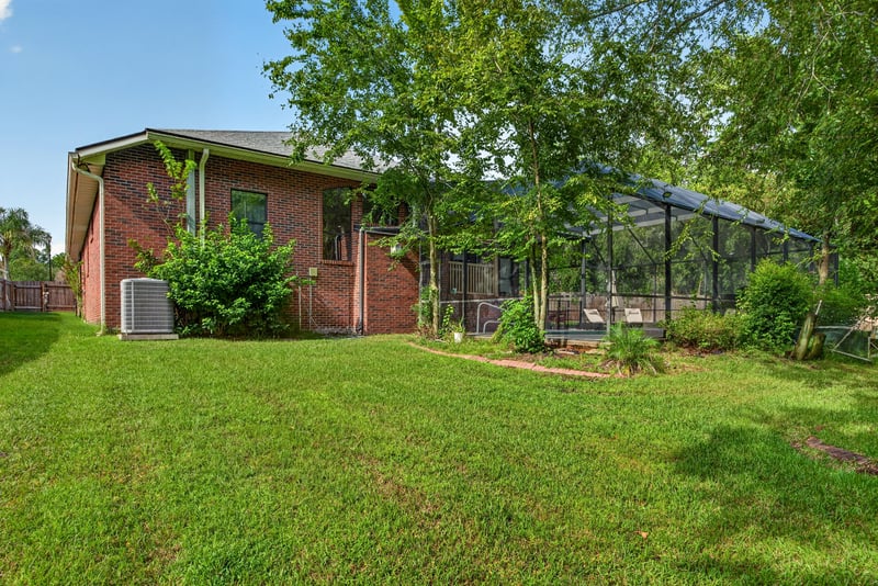 Backyard lawn with brick home exterior at 2125 Blue Heron Cove Dr, Orange Park, FL 32003