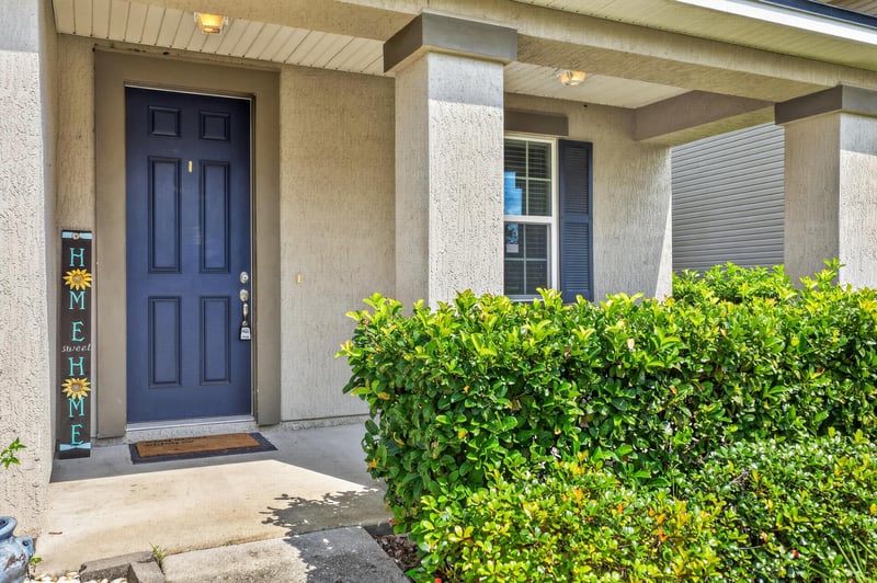 Front door with navy paint and covered entry columns at 263 Gilmore Ln, Orange Park, FL 32065
