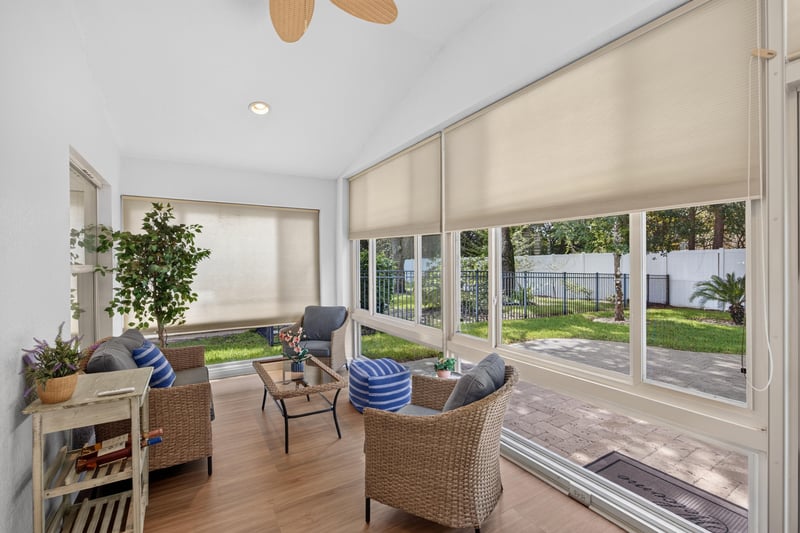 Sunroom with sliding glass doors and wicker chairs at 11225 Water Spring Cir, Jacksonville, FL 32256