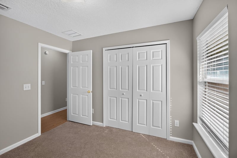 Carpeted bedroom with double closet doors at 14147 Fish Eagle Dr E, Jacksonville, FL 32226