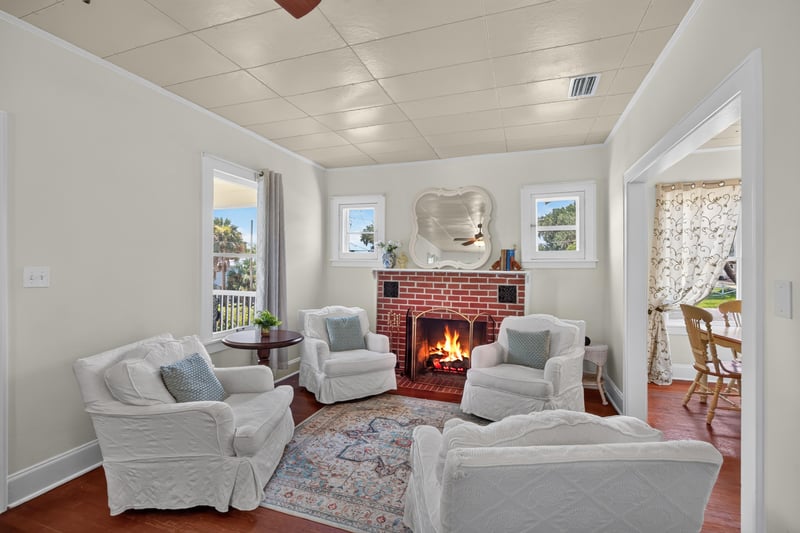 Living room with fireplace and lace-curtained windows at 101 N Lake St, Crescent City, FL
