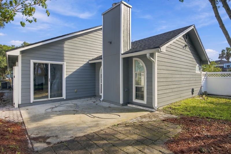 Rear exterior with patio and sliding door at 678 5th Ave N, Jacksonville Beach, FL 32250