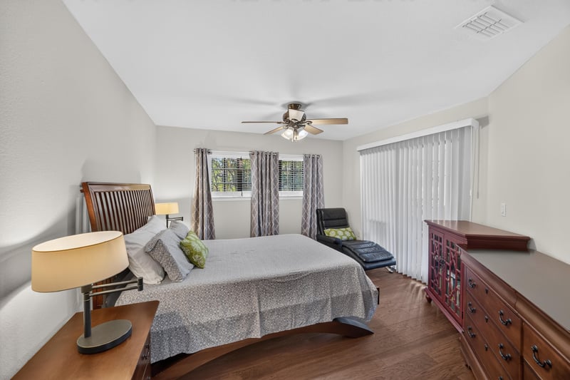 Bedroom with ceiling fan and wood nightstands at 10150 Belle Rive Blvd, Jacksonville, FL