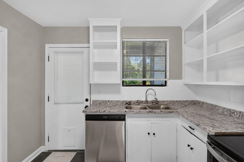 Kitchen sink area with dishwasher and built-in shelves at 6338 Mercer Cir W, Jacksonville, FL