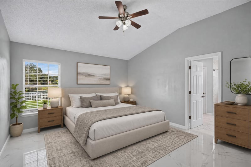 Staged primary bedroom with bed and ceiling fan at 490 Hillside Dr, Orange Park, FL 32073
