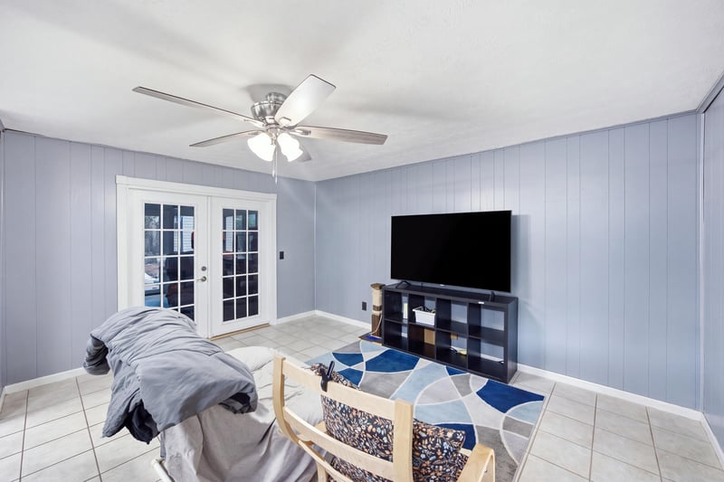 Living room with french doors and TV at 417 Capricorn Ln, Orange Park, FL 32073