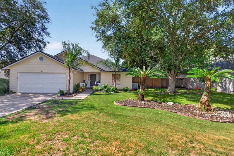 Front exterior with palm trees and lawn at 8680 Bandera Cir S, Jacksonville, FL 32244