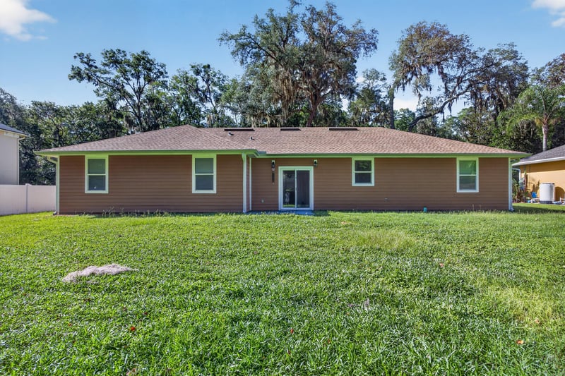 Rear exterior with lawn and back door at 1012 Fruit Cove Rd, Jacksonville, FL 32259