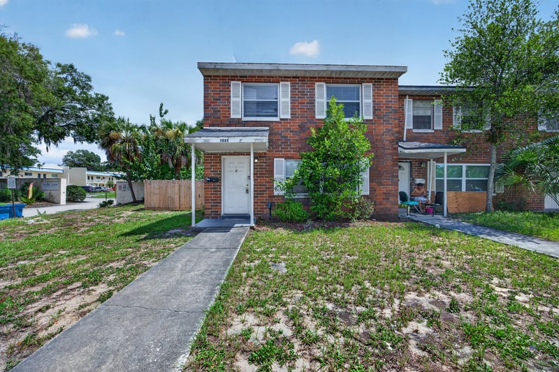 Brick two-story townhouse exterior with walkway and front lawn at 2658 Trollie Ln apt 1, Jacksonville, FL 32211