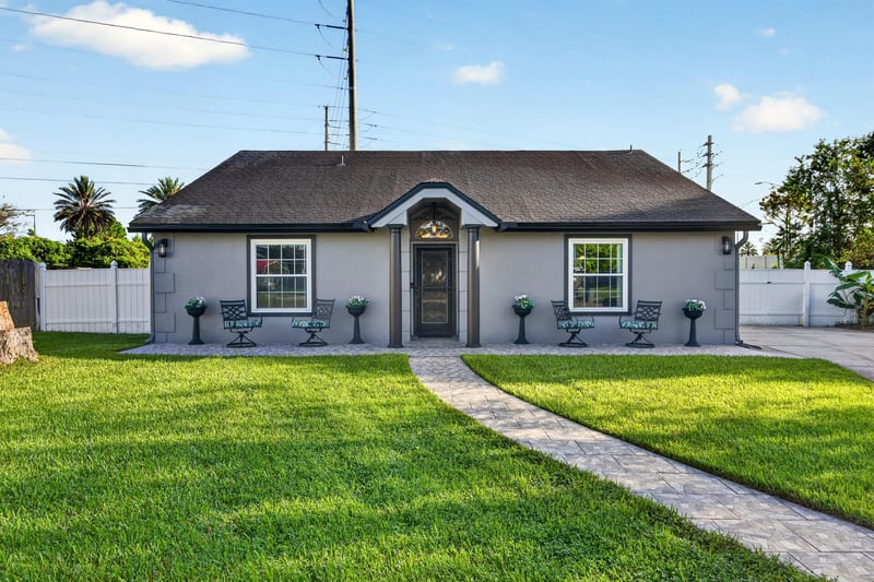 Front exterior with arched entry and manicured lawn at 6931 Cane Grass Ln E, Jacksonville, FL 32244