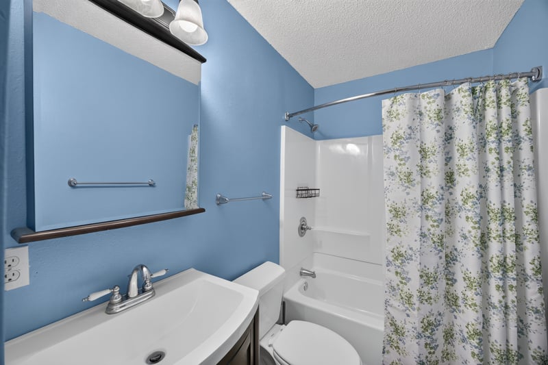 Bathroom with blue walls and floral shower curtain at 892 Branscomb Rd, Green Cove Springs, FL