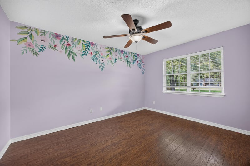 Bedroom with lavender walls and painted floral mural at 892 Branscomb Rd, Green Cove Springs, FL