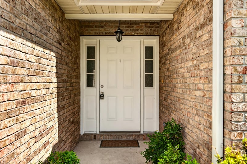 Front entry door with glass sidelights and brick surround at 490 Hillside Dr, Orange Park, FL 32073
